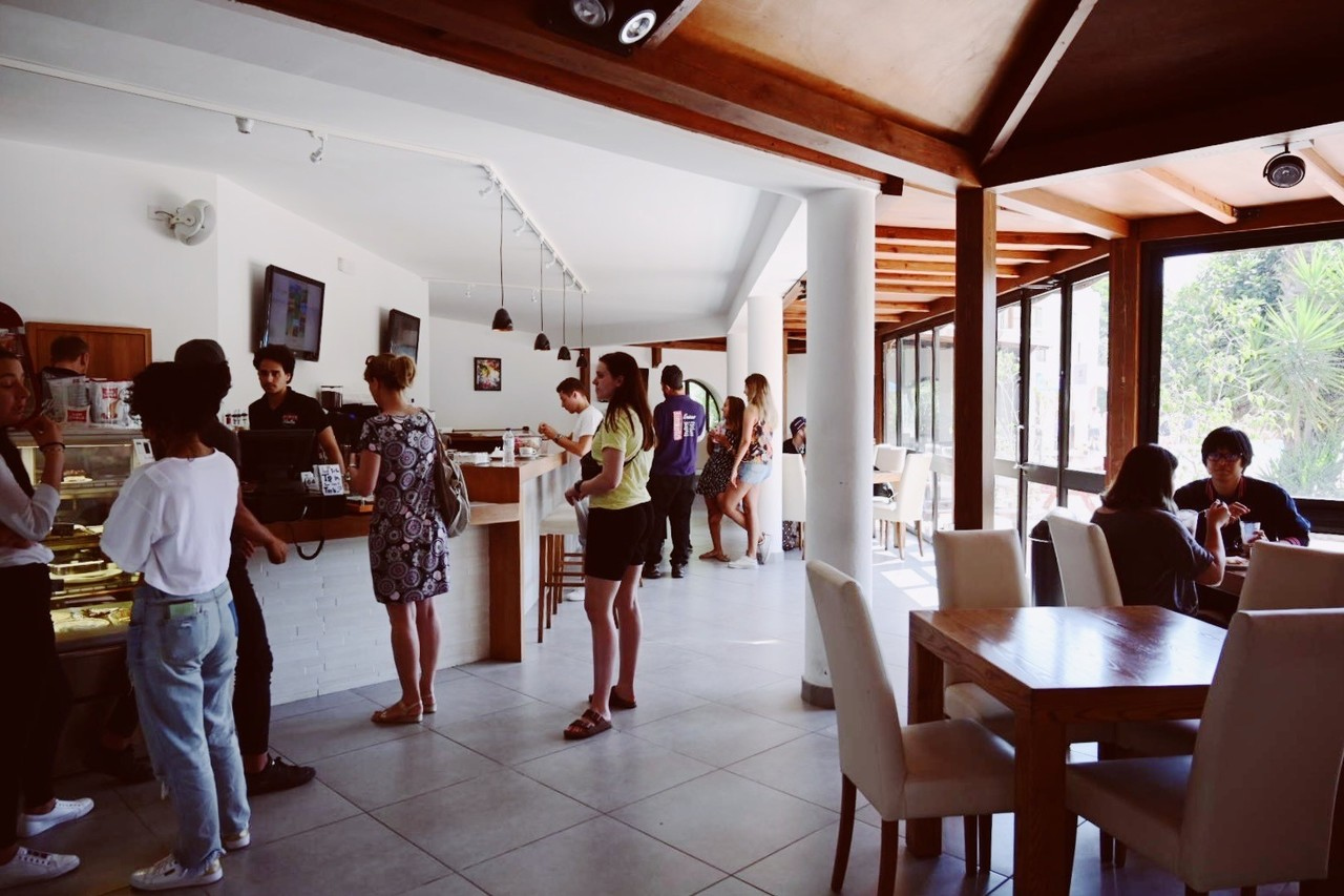 Students ordering food and chatting inside the bright and modern café at the Sprachcaffe Malta campus.