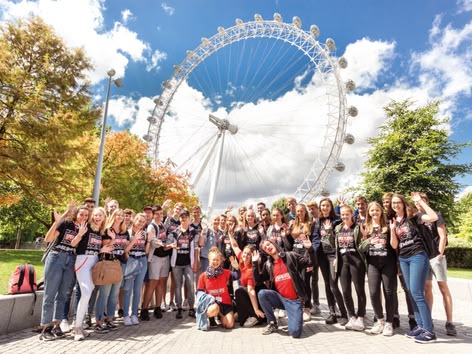 Sprachcaffe student group posing in front of the London Eye on a sunny day.