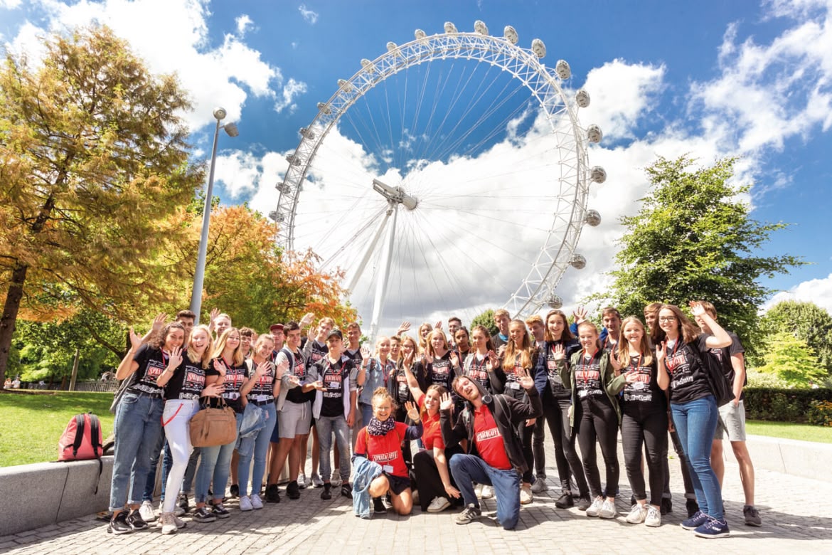 Sprachcaffe student group posing in front of the London Eye on a sunny day.
