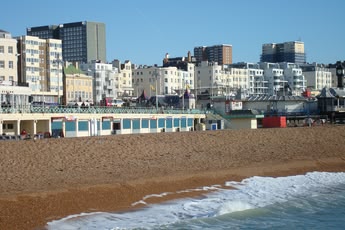Widok na kamienistą plażę w Brighton z charakterystyczną nadmorską zabudową w tle, tworzącą klasyczny krajobraz brytyjskiego kurortu