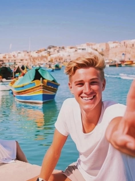 Girl sitting by the harbour in Malta, overlooking colourful traditional boats in the clear blue water.