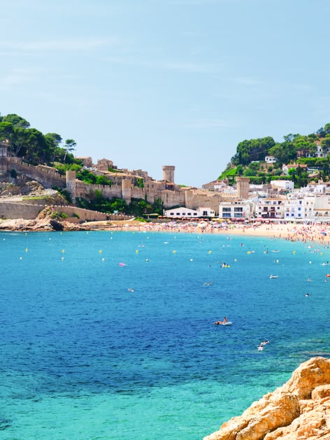 Eine wunderschöne Küste in Spanien bei gutem Wetter. Im Hintergrund befindet sich eine kleine Stadt im spanischen Stil.