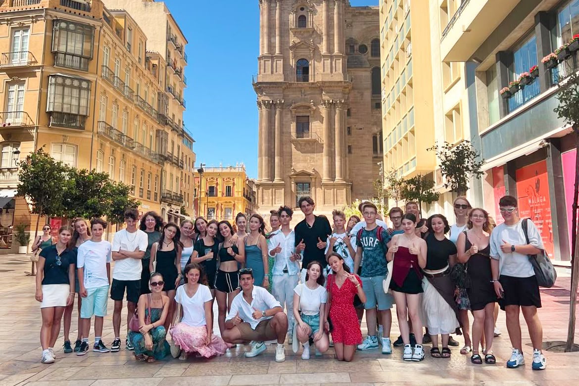 Large student group posing in front of Málaga Cathedral during a Sprachcaffe excursion.