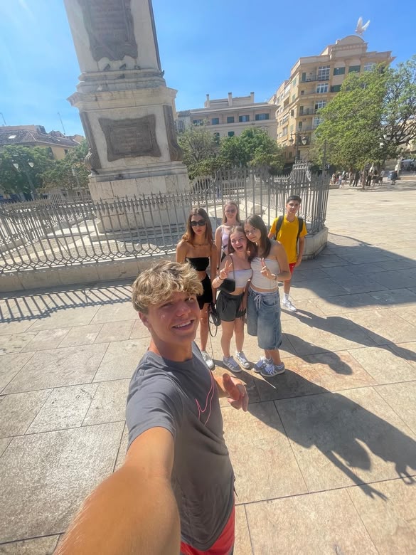 Teen students taking a selfie at a historic square in Málaga during a Sprachcaffe trip.