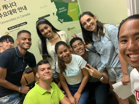 Diverse group of Sprachcaffe students smiling together in a Canadian classroom.