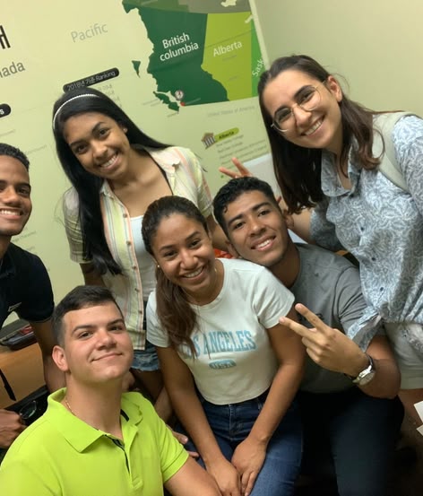 Diverse group of Sprachcaffe students smiling together in a Canadian classroom.