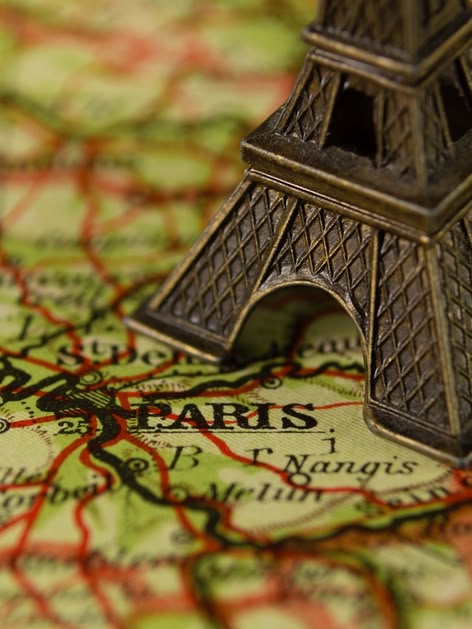La Torre Eiffel situada sobre un mapa de la ciudad de París