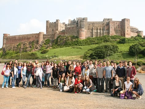 Large student group in front of a historic English castle during a Sprachcaffe trip.