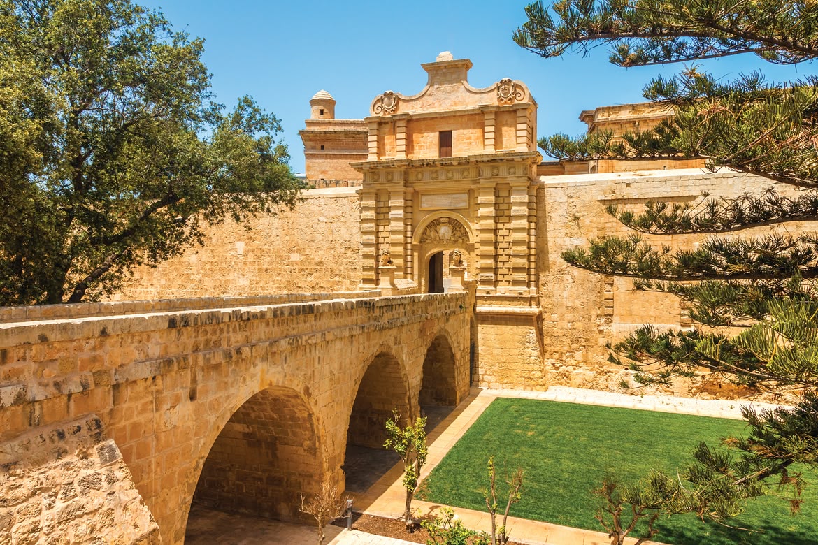 Historic stone gate and bridge entrance to the walled city of Mdina, Malta.