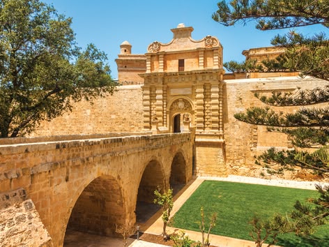 Historic stone gate and bridge entrance to the walled city of Mdina, Malta.