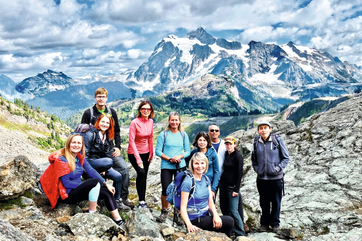 Group of hikers posing in the mountains during an outdoor excursion.